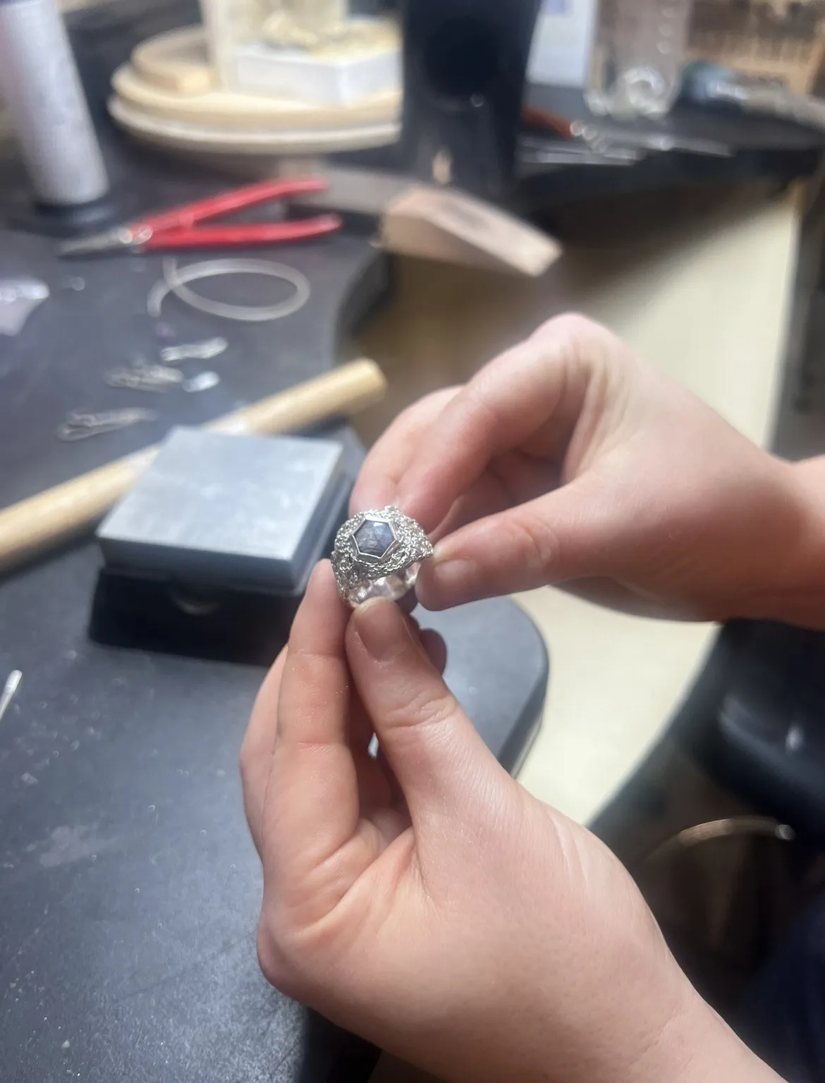 Georgina Hopkin holding a silver ring set with a grey sapphire