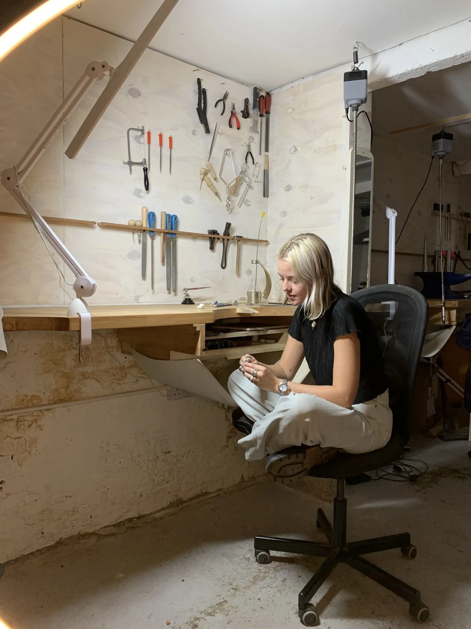 A jeweller at her bench in the jewellery workshop at Hone Limehouse