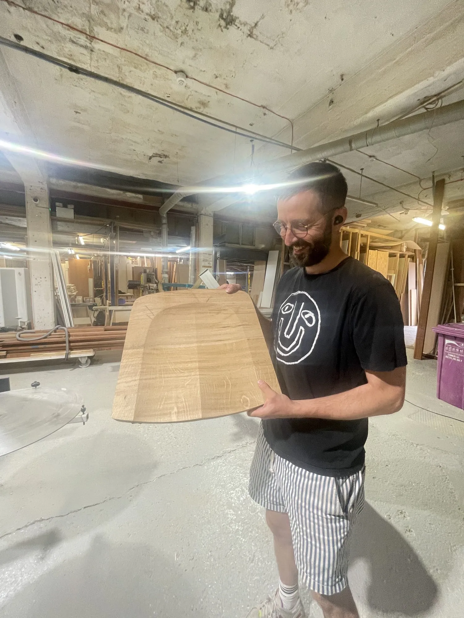 A maker holding a curved plywood shell