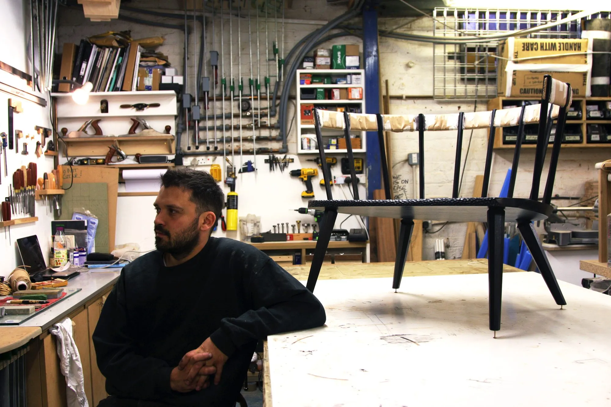 A furniture maker with a chair frame at his bench
