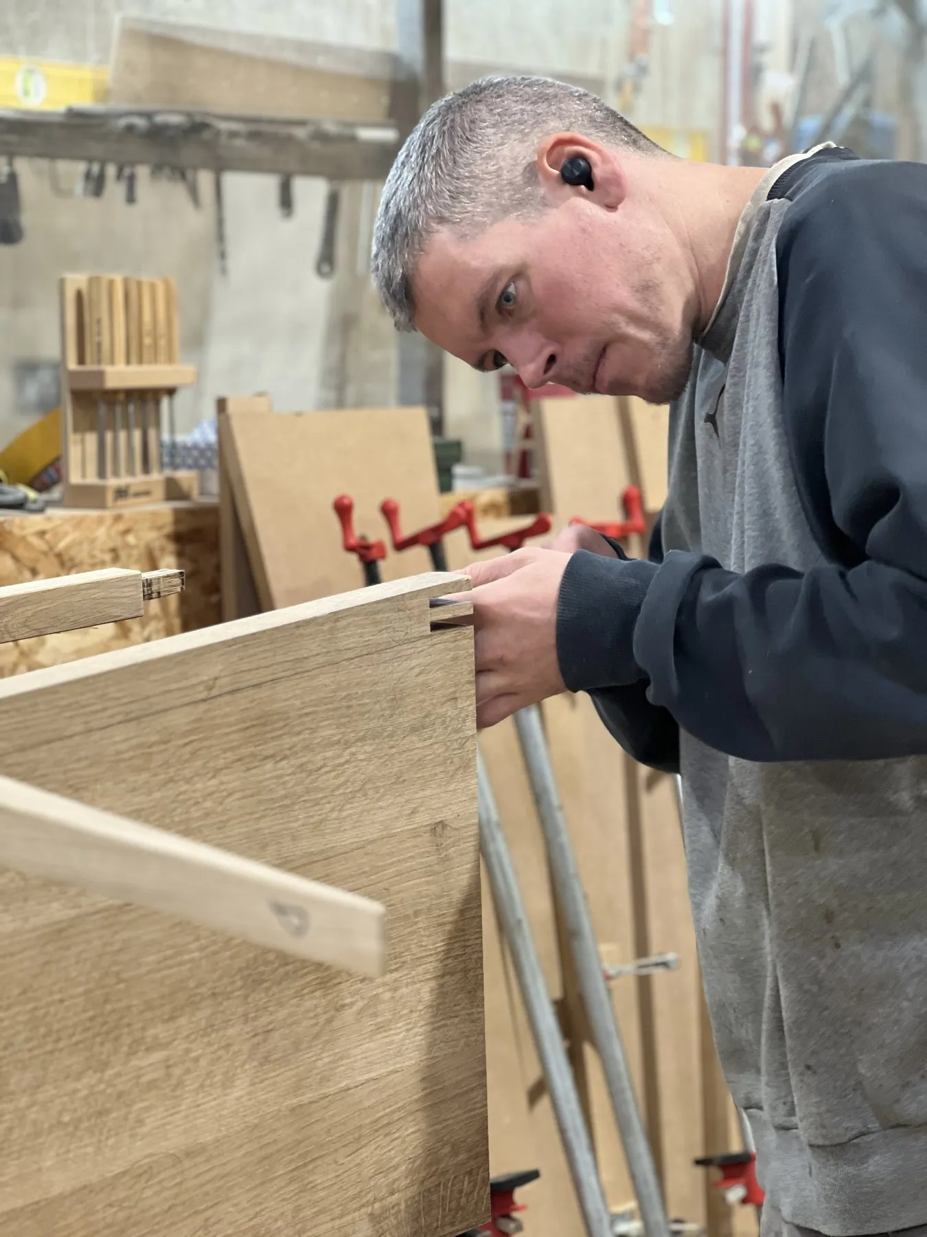 A furniture maker clamping up a cabinet in the woodwork shop