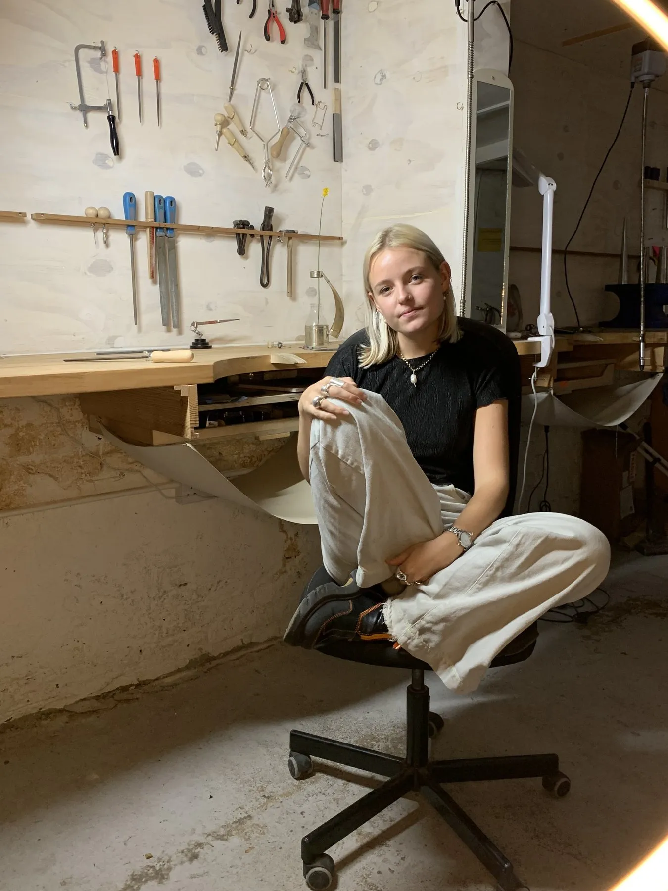 A jeweller at her bench in the jewellery workshop