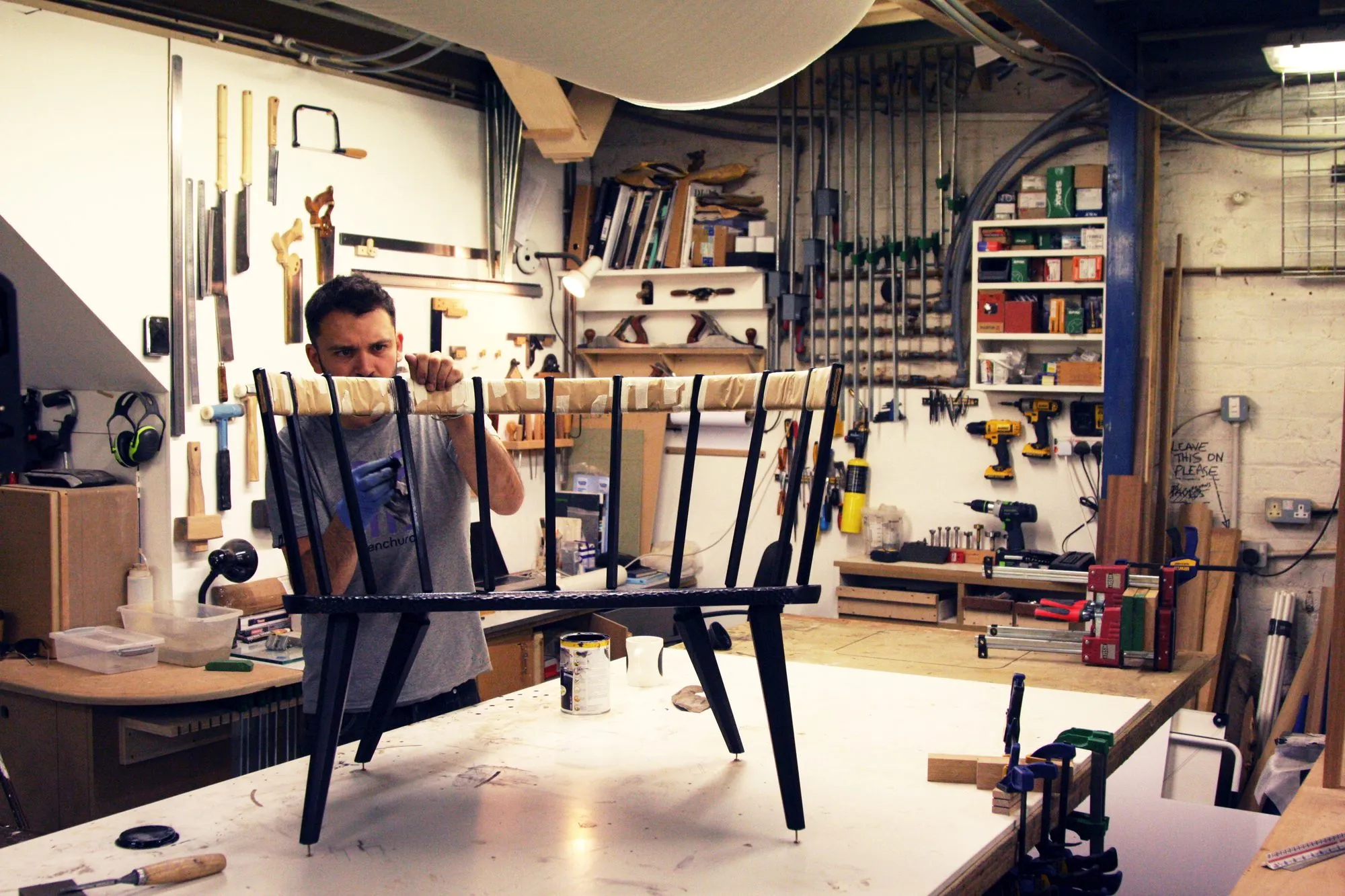 A member assembling a chair at his bench