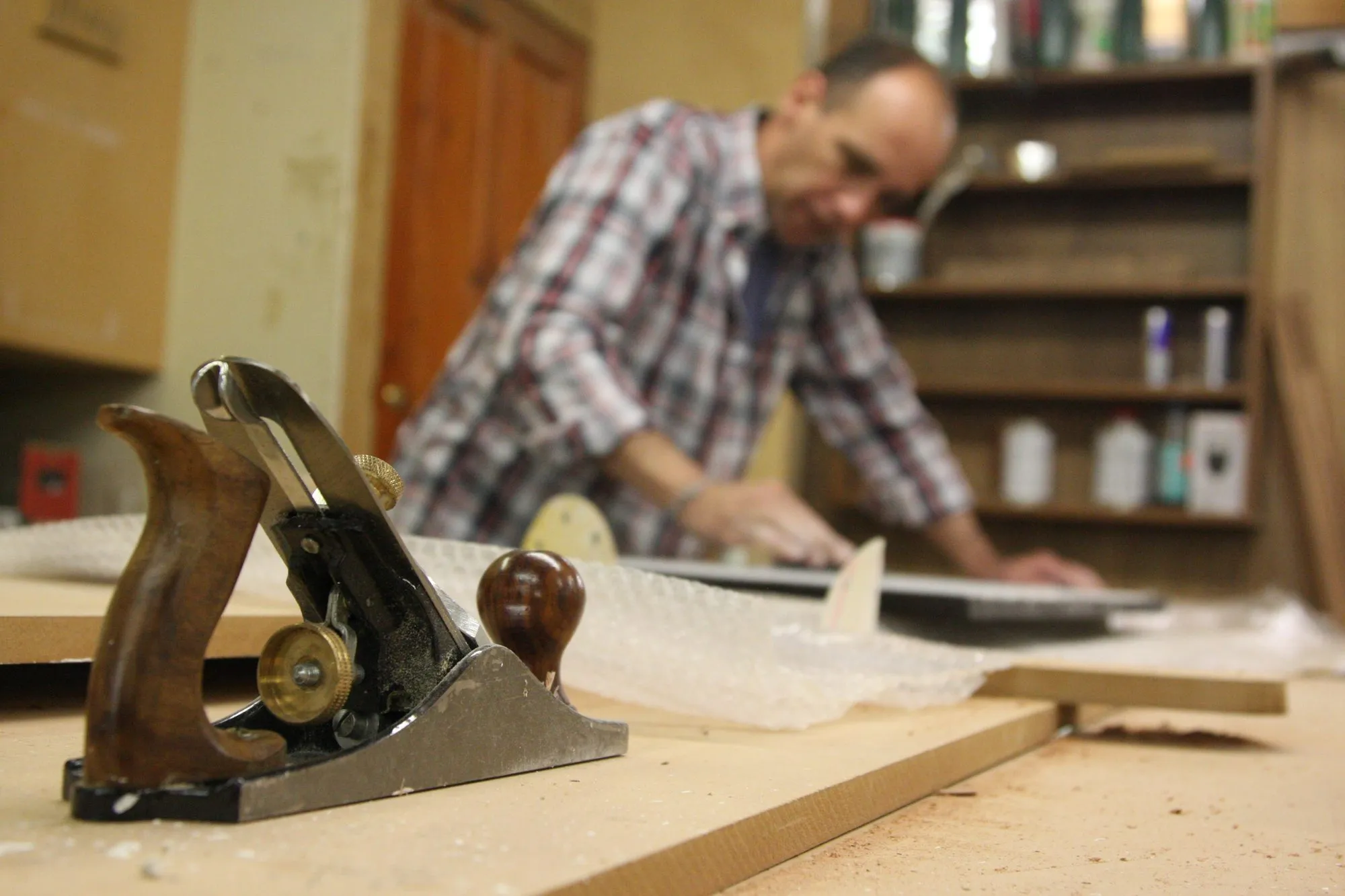 A hand plane in use on a board